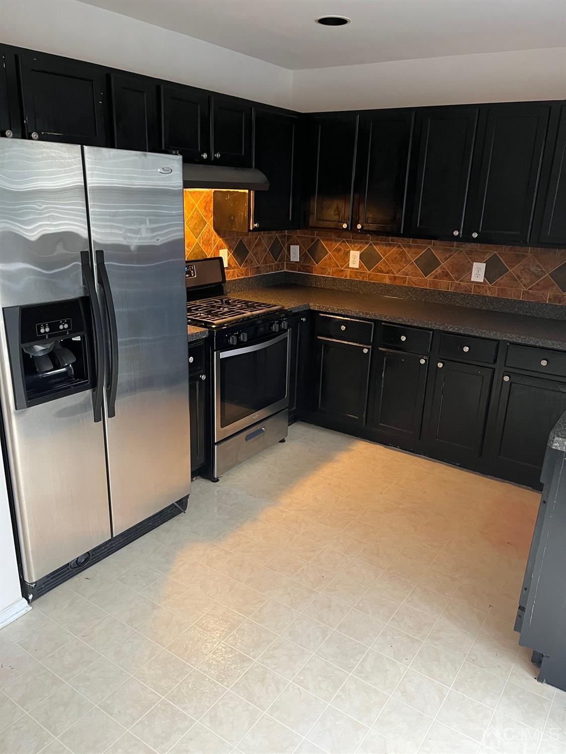1711 Ridgeview Court Sayreville, NJ 08859 - Photo 3 of 18 a kitchen with stainless steel appliances a refrigerator and a stove