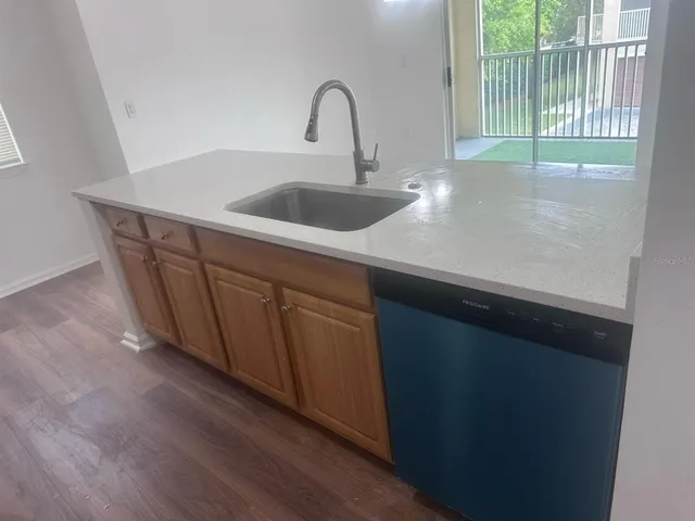 a kitchen with a sink and wooden cabinet