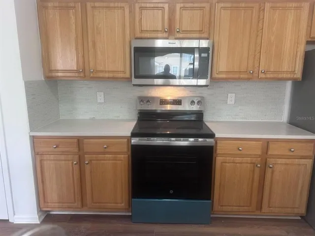 a kitchen with granite countertop white cabinets and stainless steel appliances