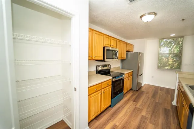 a large kitchen with a sink stainless steel appliances and cabinets