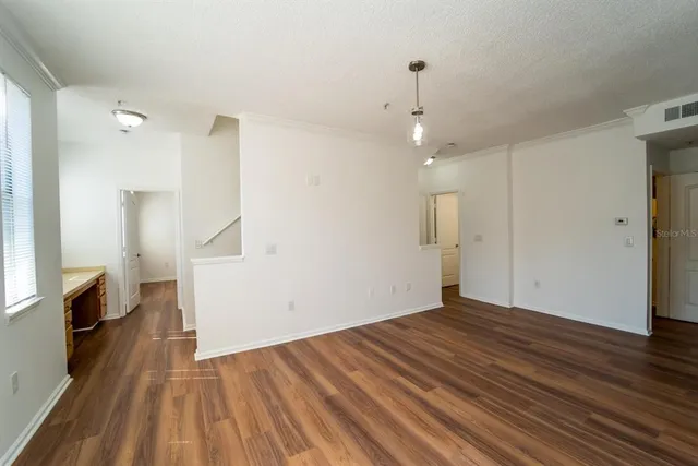 a view of a room with wooden floor and a ceiling fan