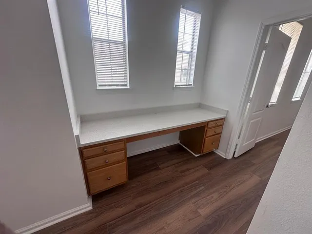 a view of a hallway with wooden floor and stairs