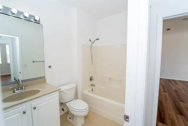 an empty room with a window and a ceiling fan