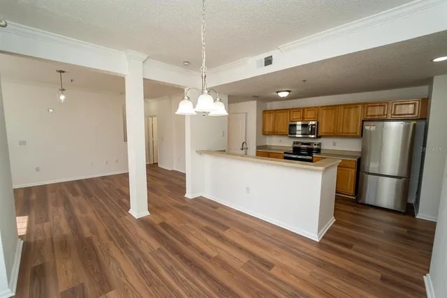 a kitchen with a refrigerator a stove top oven a sink and wooden floor