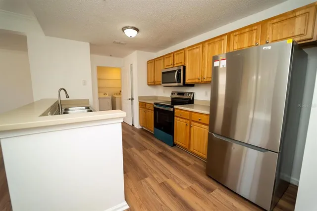 a kitchen with stainless steel appliances a refrigerator sink and microwave