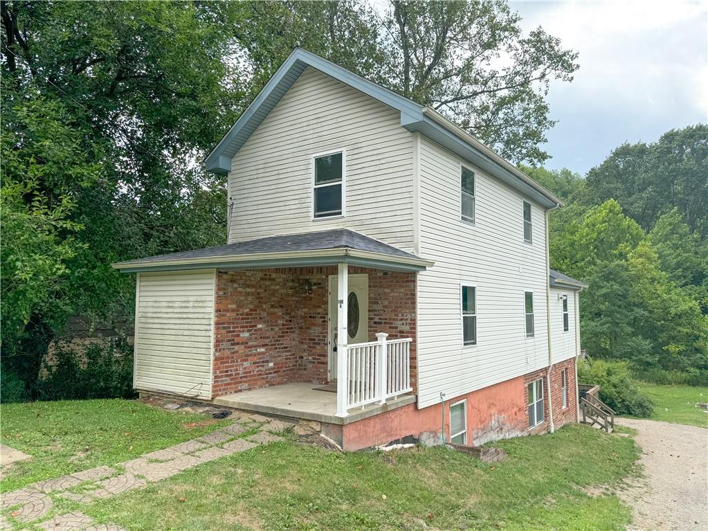 a view of a white house with a big yard and large trees