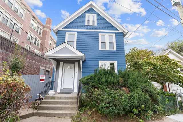 a front view of a house with a garden