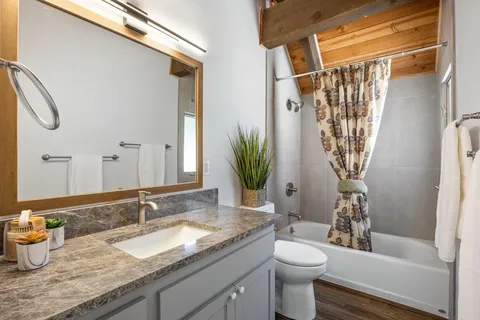 a bathroom with a granite countertop sink toilet and shower