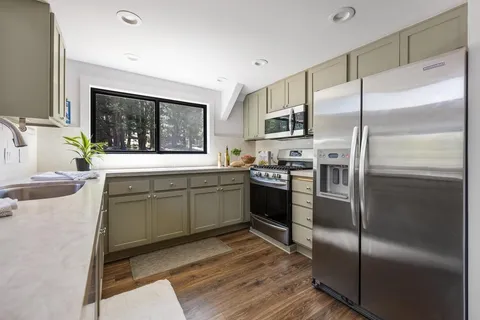 a kitchen with a refrigerator sink and cabinets