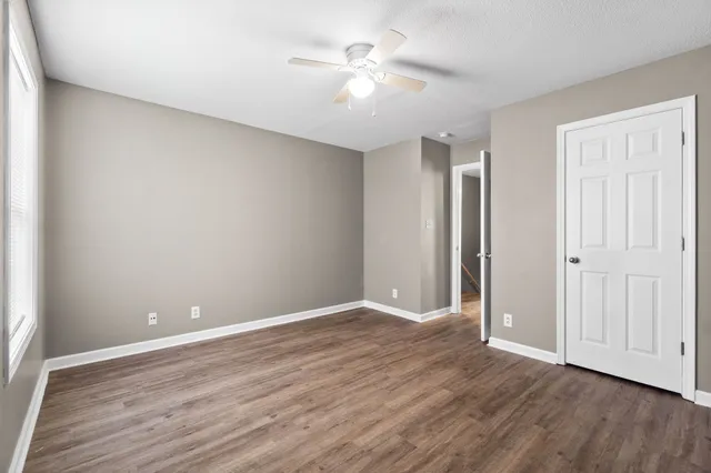 a view of an empty room with wooden floor
