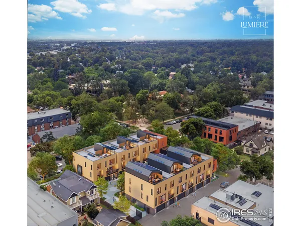 an aerial view of residential houses with outdoor space and trees