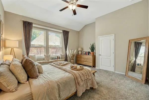 a spacious bedroom with a bed and glass walk in closet