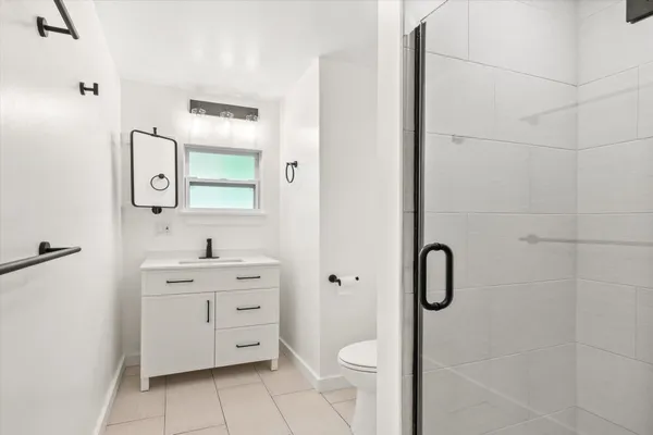 a bathroom with a toilet sink vanity and mirror