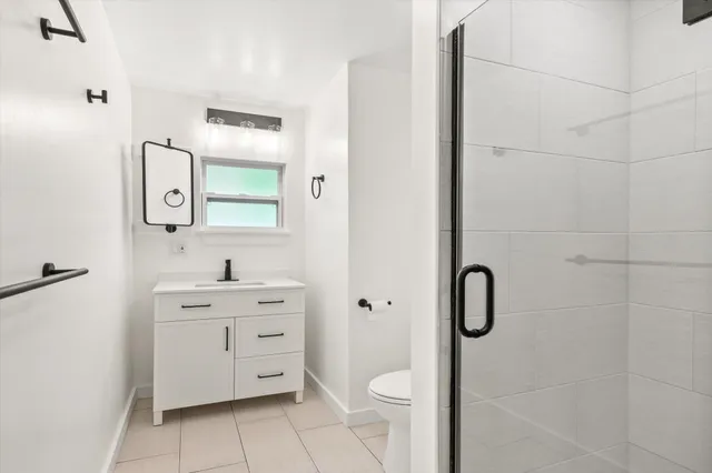 a bathroom with a toilet sink vanity and mirror