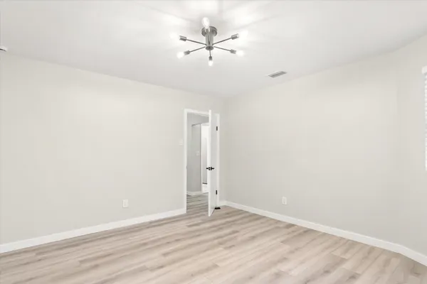 an empty room with a ceiling fan and wooden floor