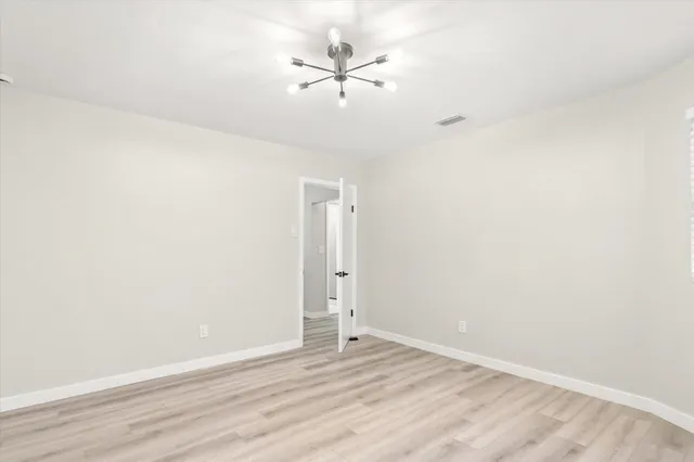 an empty room with a ceiling fan and wooden floor