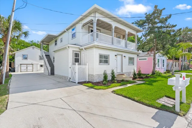 a front view of a house with garden and trees
