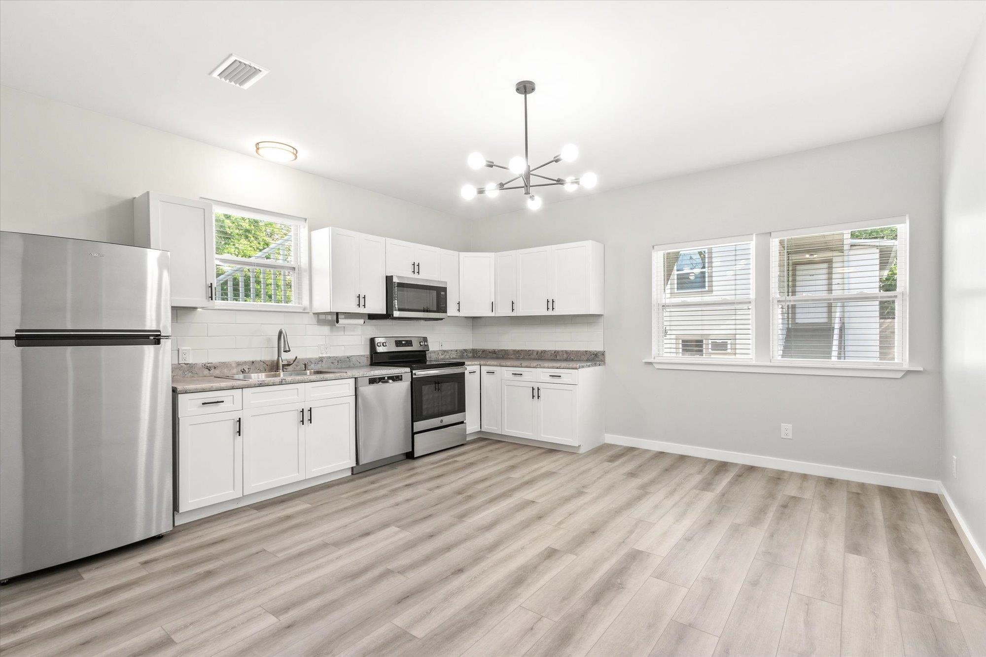 28 Sebastian Avenue St. Augustine, FL 32084 - Photo 5 of 24 a kitchen with granite countertop white cabinets and refrigerator