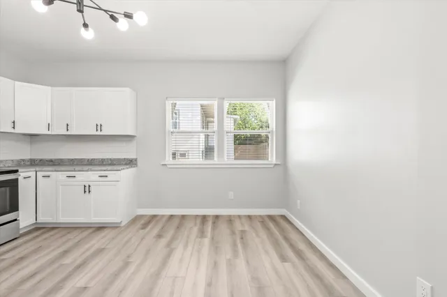 a view of a kitchen with wooden floor and electronic appliances