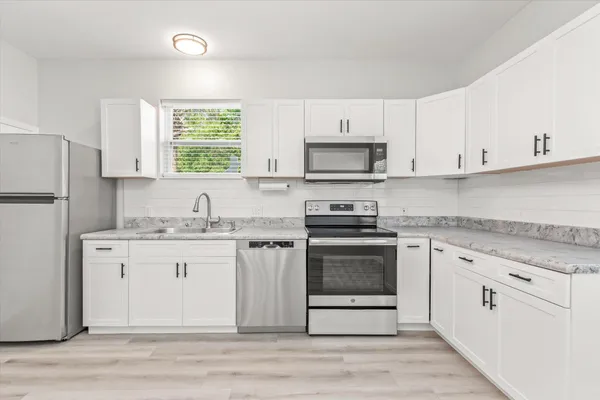 a kitchen with stainless steel appliances granite countertop a stove a sink and a refrigerator