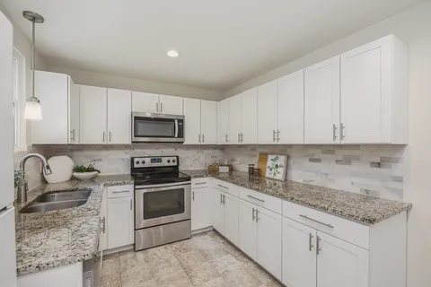 a kitchen with sink a microwave and cabinets