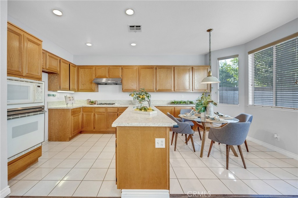 738 Orchard Loop Azusa, CA 91702 - Photo 17 of 50 a kitchen with a sink a stove and chairs