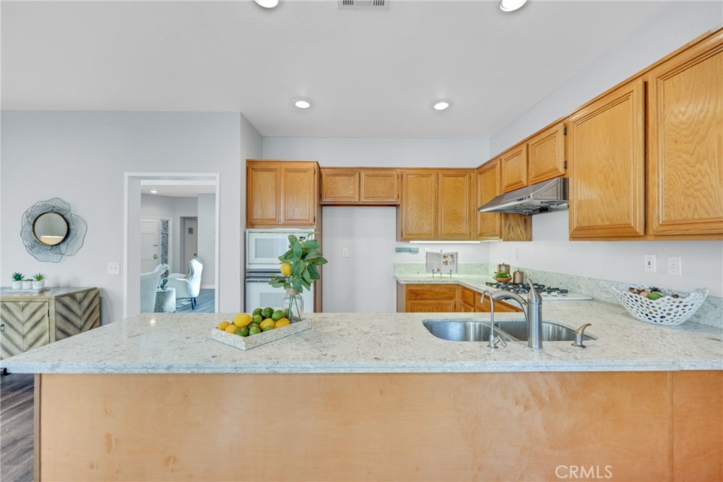 738 Orchard Loop Azusa, CA 91702 - Photo 20 of 50 a kitchen with stainless steel appliances granite countertop a sink and a white cabinets