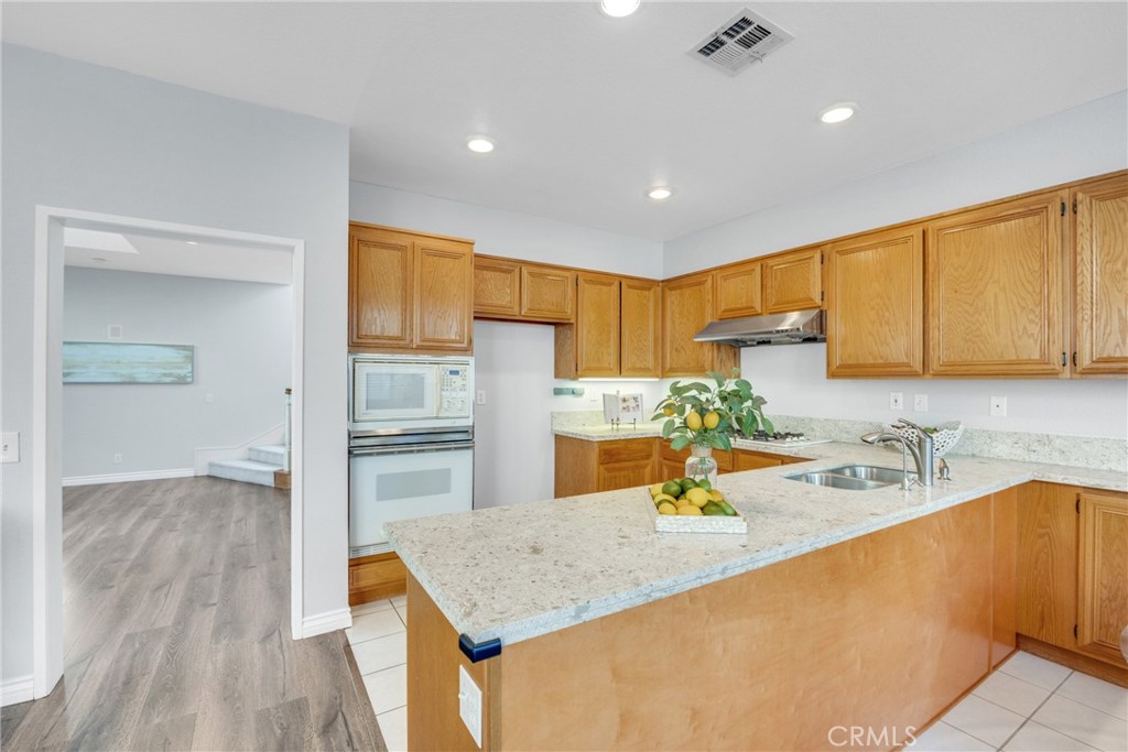 738 Orchard Loop Azusa, CA 91702 - Photo 21 of 50 a kitchen with stainless steel appliances granite countertop a sink refrigerator and cabinets