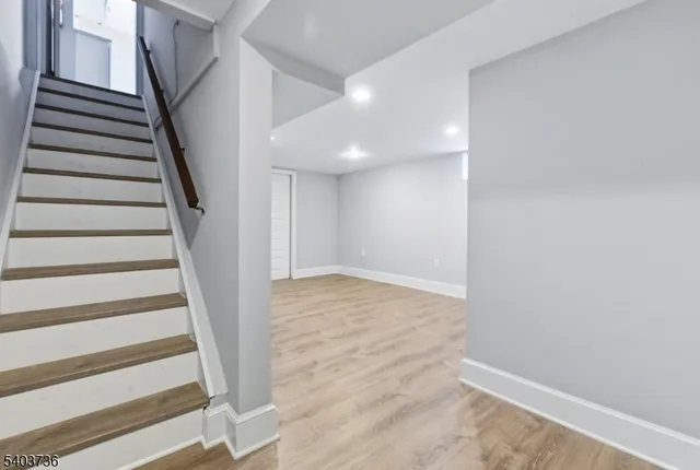 a view of staircase with wooden floor and white walls