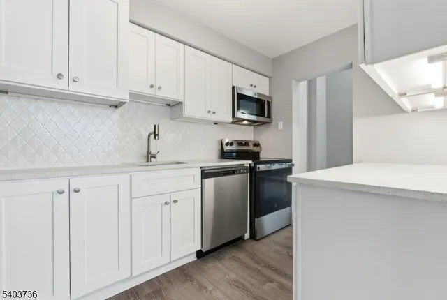 a kitchen with white cabinets and stainless steel appliances
