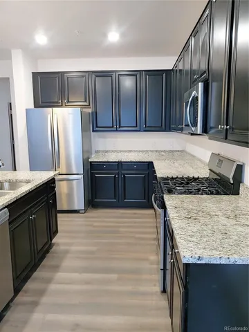 a kitchen with stainless steel appliances granite countertop wooden cabinets a sink and a oven