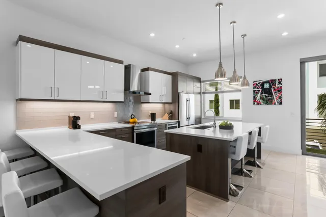 a kitchen with kitchen island a white cabinets and chairs