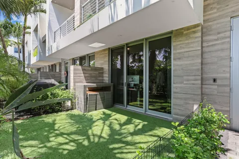 an aerial view of residential houses with outdoor space and trees around
