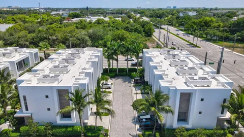 a view of a white house with a yard and potted plants