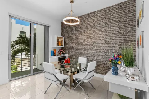 a living room with furniture floor to ceiling window and a flat screen tv