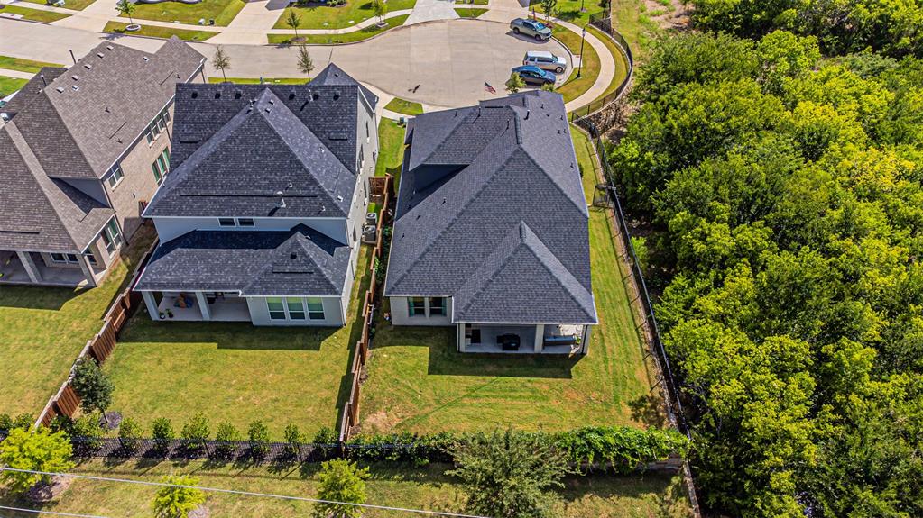 1070 Adair Road Prosper, TX 75078 - Photo 35 of 40 Expansive residential property featuring a dark shingle roof and a spacious green lawn