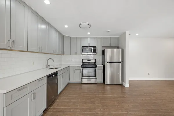 a kitchen with stainless steel appliances granite countertop a refrigerator sink and cabinets