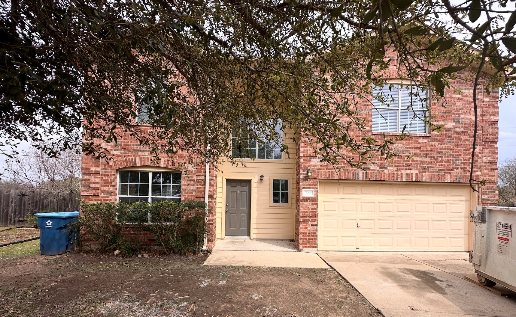 722 Lavaca Loop Elgin, TX 78621 - Photo 1 of 24 View of property hidden behind natural elements with brick siding, a garage, and driveway
