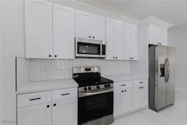 a kitchen with stainless steel appliances a refrigerator sink and microwave