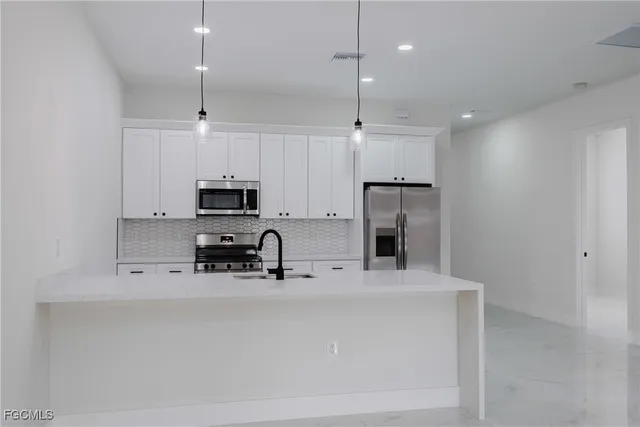 a kitchen with stainless steel appliances and refrigerator
