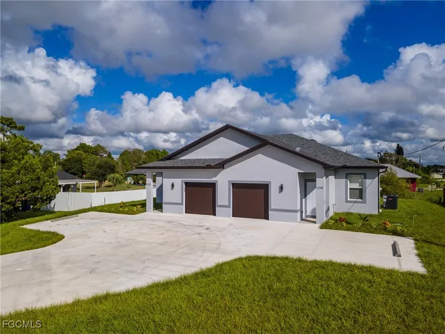a view of a house with a big yard and potted plants