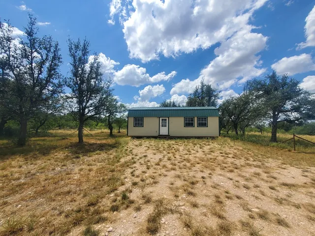 a large tree in front of a house with a yard