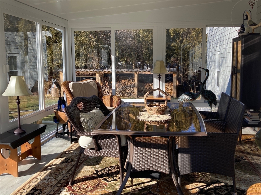 17 Brookside Drive Acushnet, MA 02743 - Photo 26 of 41 a living room with furniture a flat screen tv and a floor to ceiling window