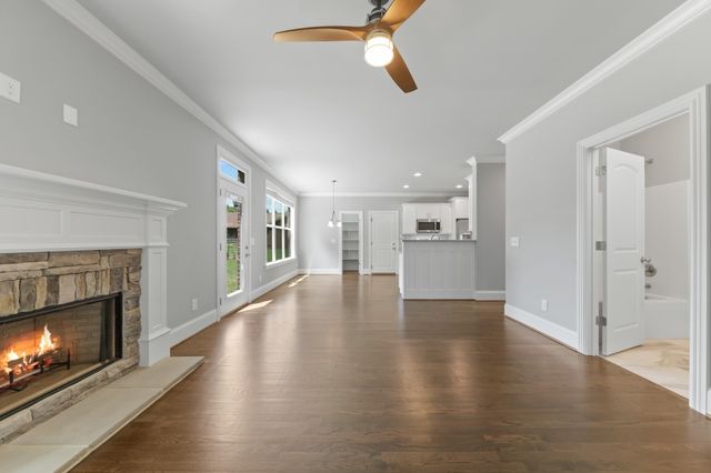 a view of an empty room with wooden floor fireplace and a window