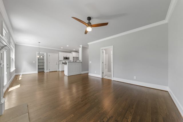 a view of empty room with wooden floor and window