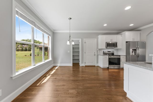 a large kitchen with stainless steel appliances granite countertop a stove a sink and a refrigerator