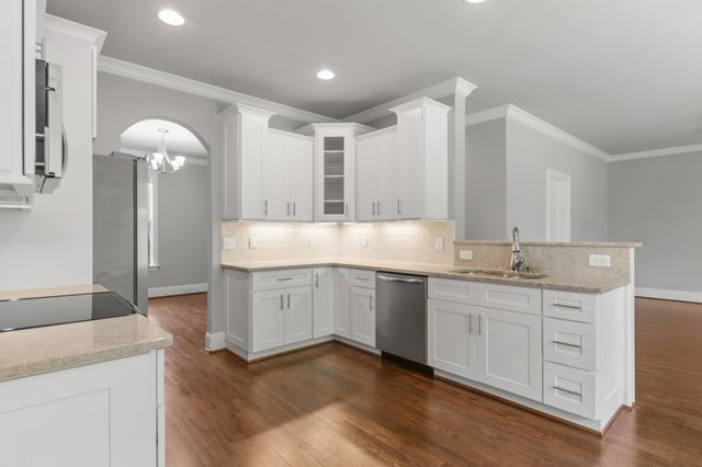 a kitchen with granite countertop white cabinets and white appliances