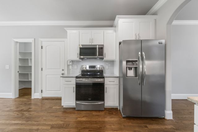 a large kitchen with kitchen island a large counter top space a sink stainless steel appliances and cabinets