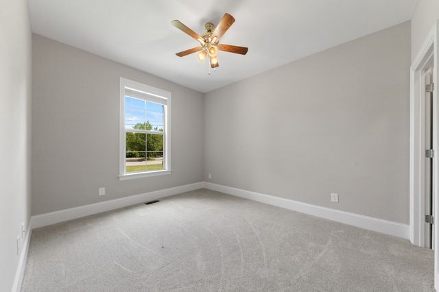 an empty room with a window and a ceiling fan