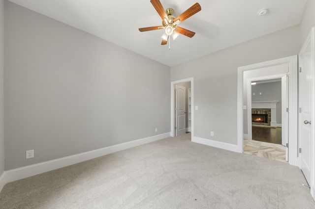 an empty room with closet and a chandelier fan